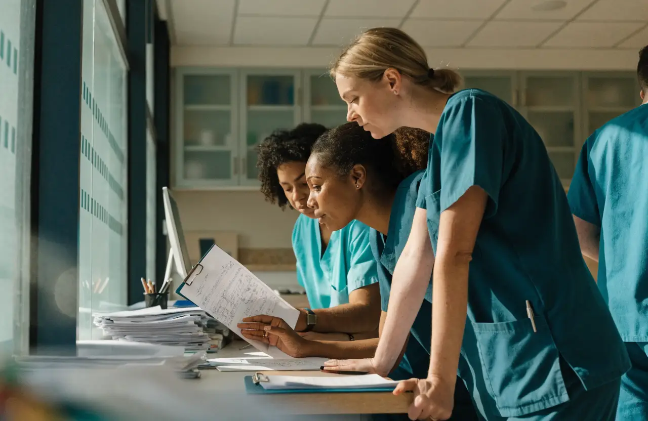 Healthcare staff collaborating at a nursing station